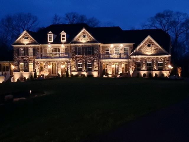 Stone house at night with warm Christmas uplights